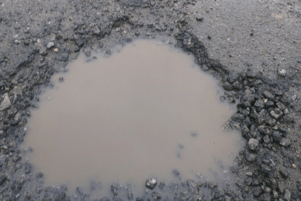 water-filled pothole on a driveway 